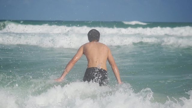Young man going into the sea in slow motion. happy summer vacation rest relax recreation area water. 1920x1080, hd
