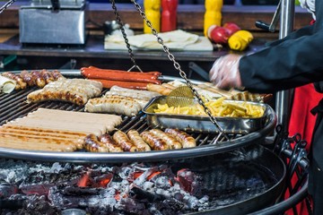 french fries, with burning fire on a portable barbecue with sausage, lavash.