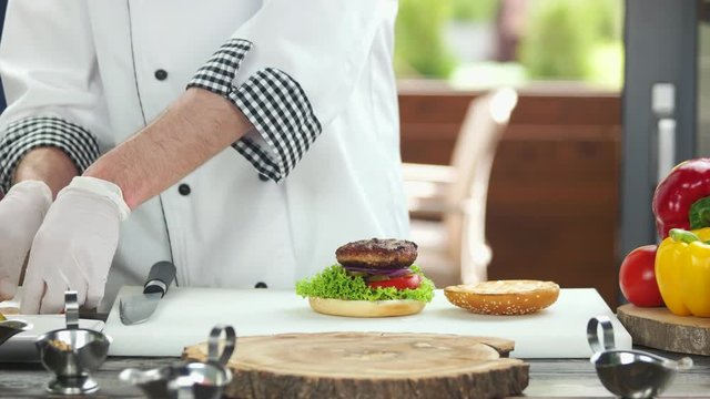 Chef making a delicious burger. Vegetables, meat and egg.