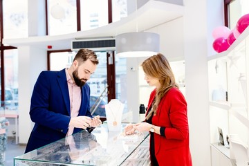 Attractive man with a beard choosing a valentine's day gift in jewelry store