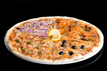 Slices of traditional Italian delicious pizza with different topping on dark background