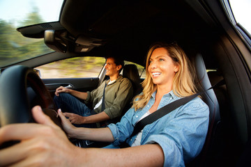 Close up attractive couple laughing in car on road trip