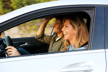 attractive woman driving car with boyfriend next to her
