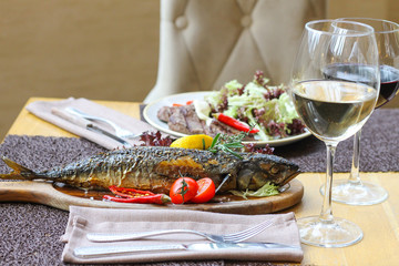 Baked mackerel with vegetables and a glass of white wine - restaurant serve