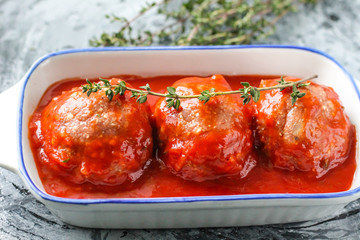Raw meatballs from beef in tomato sauce with thyme