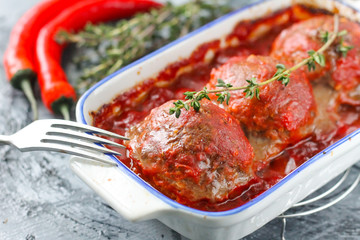 Baked meatballs from beef in tomato sauce with thyme