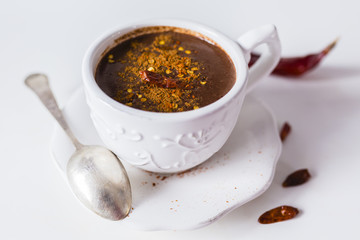 Delicious hot chocolate with chili on a white background.