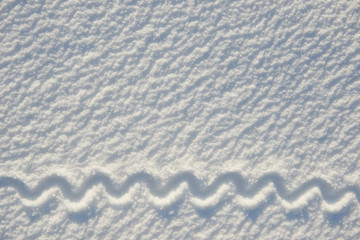 underline in wave form for text written on snow for texture or background - winter holiday concept. Sunny day, bright light with shadows, flat lay, top view, clean and nobody