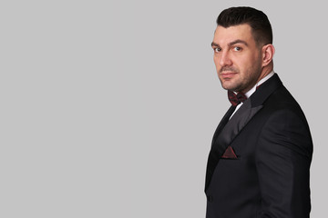 Handsome unshaven young man wearing tuxedo