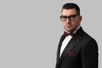 Confident man wearing tuxedo and glasses