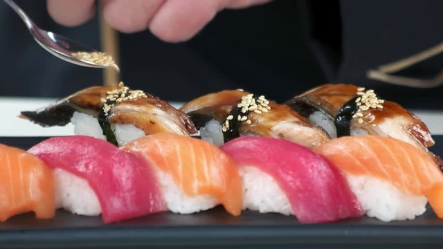 Nigiri sushi close up. Smoked eel and sesame seeds.
