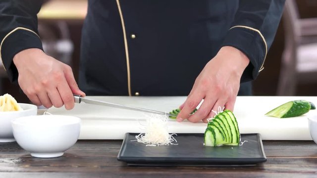 Sliced cucumber and kataifi dough. Male hands preparing food.