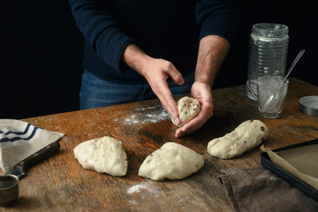 Man is cooking Easter cross buns in home kitchen