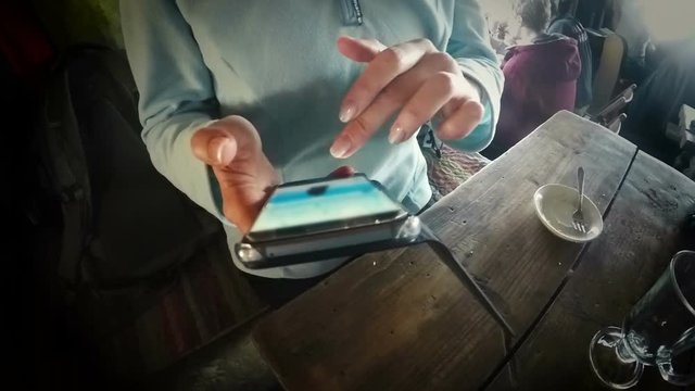 Girl in cafe connecting to internet to post vacation pictures in social media
