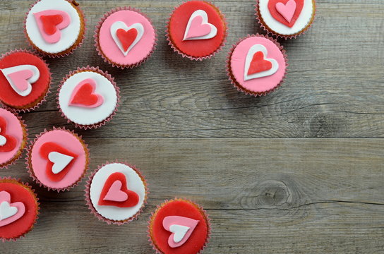 CUPCAKES decorated with hearts on stone background