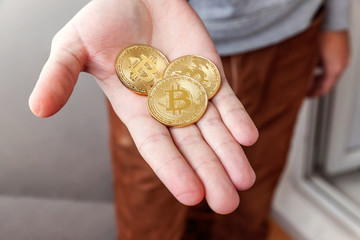 Cryptocurrency golden bitcoin coin in man hand. Electronic virtual money for web banking and...