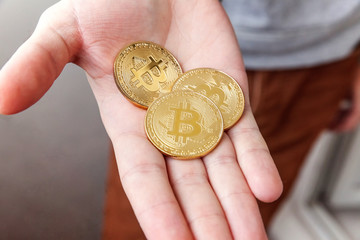 Cryptocurrency golden bitcoin coin in man hand. Electronic virtual money for web banking and...