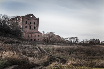 Fototapeta na wymiar Old destroyed mill on an autumn landscape. Toned