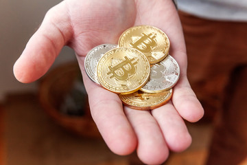 Cryptocurrency golden bitcoin coin in man hand. Electronic virtual money for web banking and...
