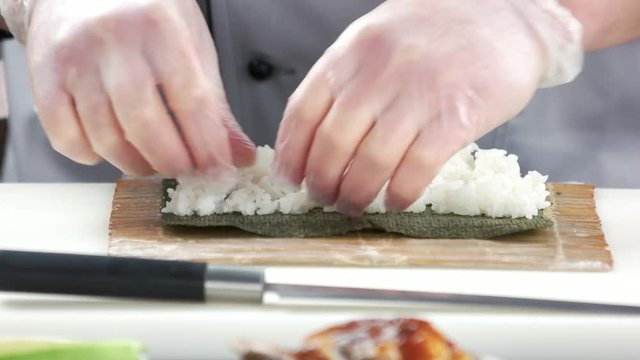 Hands making sushi close up. Nori and rice.