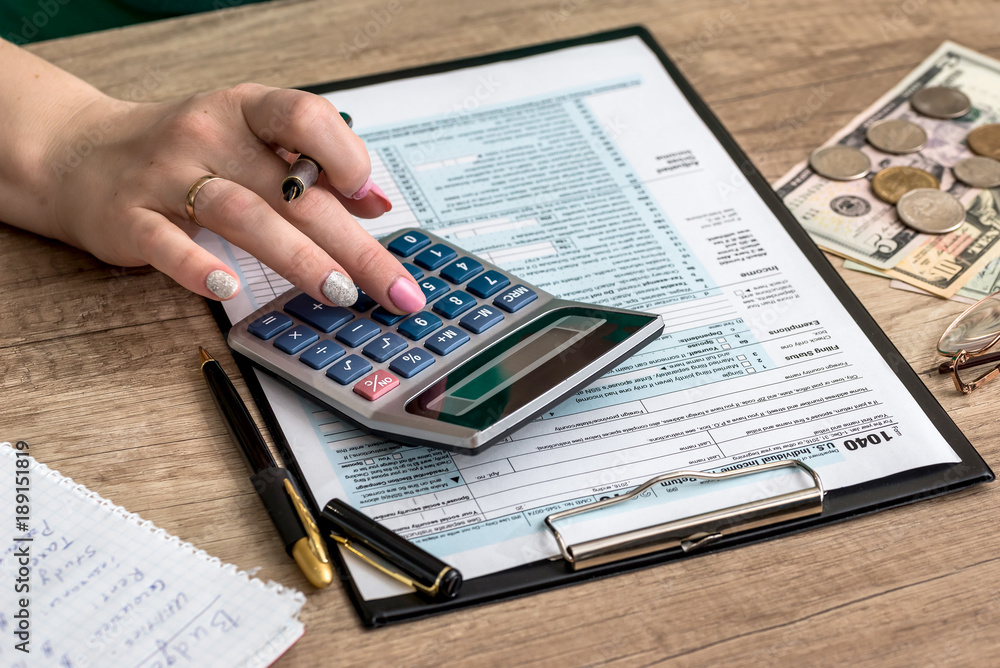 Wall mural woman filling tax form with money and calculator