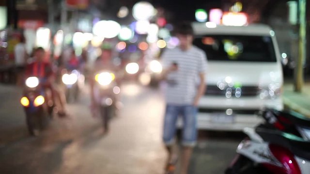 Handsome man walks on the street from blurred bokeh nackground smiles, uses his smartphone. Modern technology. 1920x1080