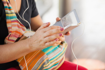Woman using smartphone or tablet, touching touchscreen, close-up; 