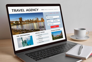 Travel agency concept on modern laptop computer screen on wooden table. All screen content is designed by me. 