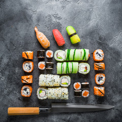 Traditional Japanese food of sushi, rolls and knife on grey background. Flat lay, Top view