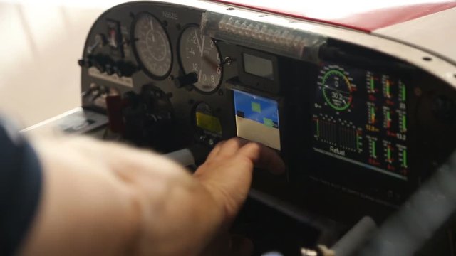 Male hand touching screen on board panel of small aircraft, course explanation