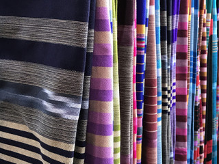 Colorful of casual silk shirts and fabric on hangers. Thai traditional pattern for fabric material.