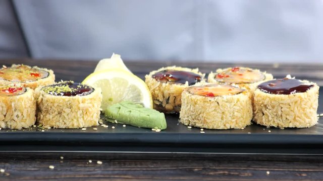 Sushi garnished with chopped pistachios. Unagi maki rolls close up.