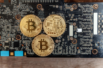 Bitcoins lie on the video card, concept of mining. Electronic virtual money for web banking and international network payment. Symbol of crypto currency