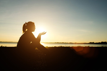 Portrait of a sad woman in a sunset with the sun in the background