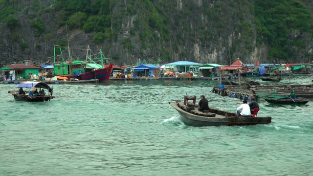 The fishing village on water. The village of fishermen in a bay in Vietnam. A large number of traditional fishing boats around the station. The village in Vietnam. Traditional boats in a bay of