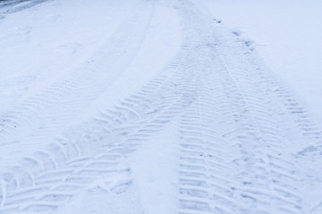 Tire tracks in the snow in the setting sun