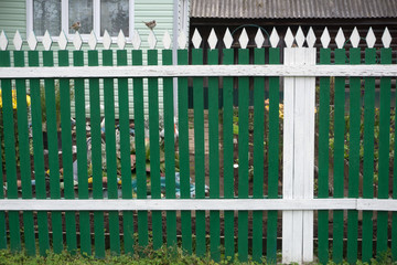 green carved wooden fence in front of the house .