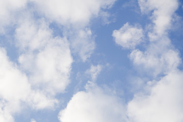 Helicopter flying over a clouds height with blue sky background .