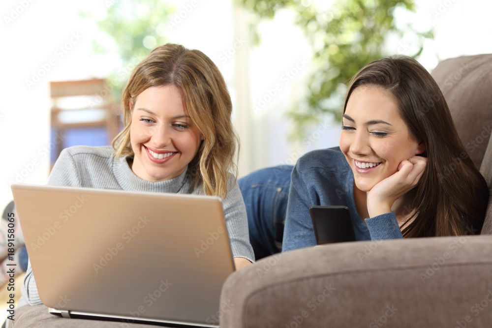 Wall mural Friends using a laptop and phone at home