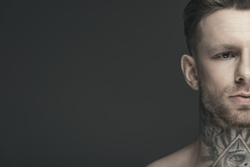 cropped view of young tattooed man, isolated on grey