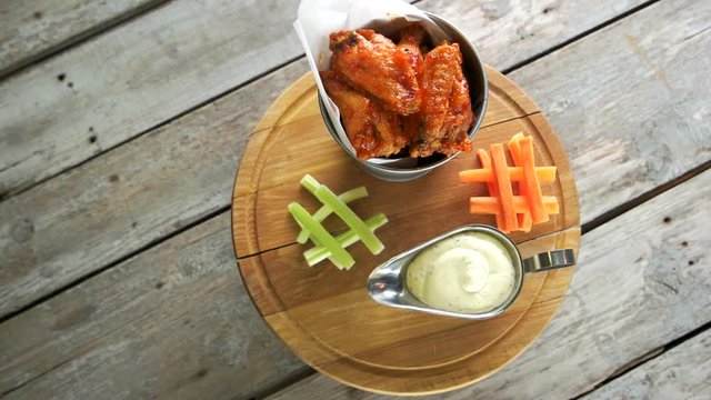 Meat appetizer with sauce. Fried chicken wings in bucket.