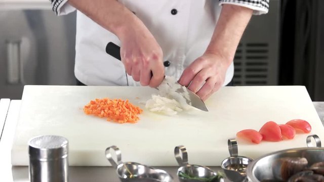 Chef chopping onion. Hands with knife, fresh vegetable.