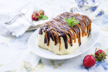 Traditional chocolate caramel cheesecake with fresh strawberries as top view on a plate
