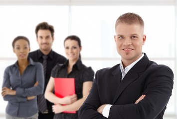 Portrait of confident young businessman and team