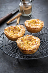 Traditional Portuguese pasteis de nata as close-up on a cooling rack
