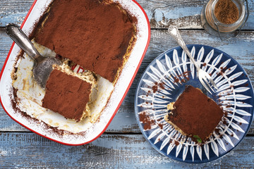 Traditional Italian tiramisu as top view on plate and in backing form