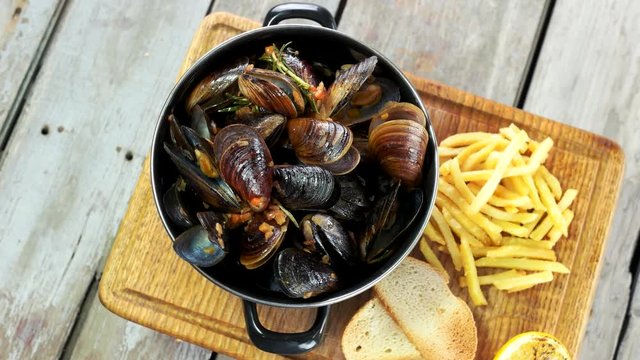Mussels with toasts and fries. Restaurant meal top view.