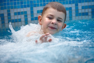 Fototapeta na wymiar Happy kid playing in pool