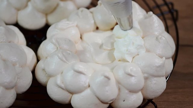 Decorate the cake Pavlova with cream