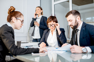 Business people working with charts and documents sitting at the table during the conference in the office